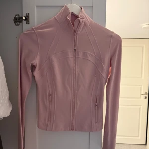 Ljusrosa jacka från Lululemon - Använd några gånger, köpt på hemsidan. Storlek 4. Dragit av lappen där bak.