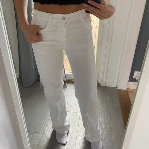 Vita raka jeans - Snygga vita jeans. Klassisk femficksmodell med bälteshällor och knappstängning. Perfekta till en fräsch och clean look. Materialet känns som bomull med lite stretch för extra komfort.