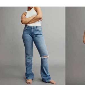 Blå bootcut jeans med slitning - Säljer ett par klassiska blå bootcut jeans med en snygg slitning på ena knät. Jeansen har hög medelmidja. Använt flera gånger därför priset är lågt men inga tecken på slitage. Men för små för mig nu o h finns inte att köpa nya just nu på hemsidan vad jag vet. 