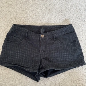Svarta prickiga shorts från H&M - Snygga svarta shorts från H&M med små vita prickar. 