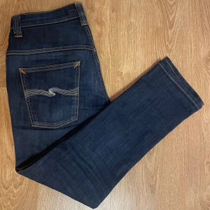 Mörkblå jeans från Nudie Jeans - Tjena, säljer mina Nudie jeans i modell Thin finn, byxorna är uppsydd i butik till L31.  Använda ett fåtal gånger då dom är i riktigt bra skick 8,5/10 Fraktar snabbt och kan diskutera pris! Nypris 1600. Jag som använt byxorna väger 70kg och är 176 lång. OBS byxorna används inte av den anledningen jag vill bli av med dom!