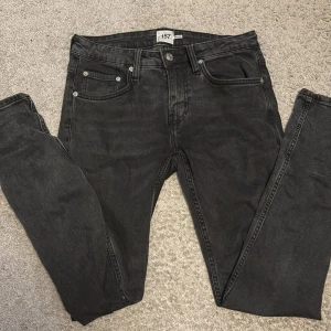 Svarta jeansbyxor från 157, Rocket S - Svarta jeansbyxor från 157, modell Rocket, i storlek S. Klassisk femficksdesign med smal passform och normal midja. Jeansen har en lätt tvättad look och är tillverkade i mjukt denimtyg som sitter snyggt på benen.