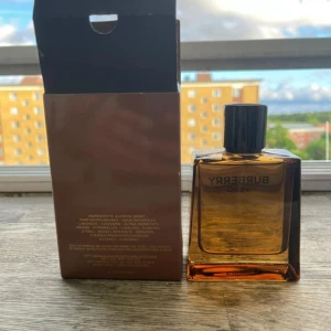 Burberry Hero Eau de Parfum 100ml - Burberry Hero Eau de Parfum i en stilren, fyrkantig glasflaska med mörk bärnstensfärg och svart kork. Doften är maskulin och modern, perfekt för dig som gillar exklusiva parfymer. Kommer med originalkartong i brunt och vitt. Flaskan rymmer 100 ml.