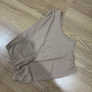 Beige topp - En beige topp i stl M som aldrig är använd säljs för 60 kr. 