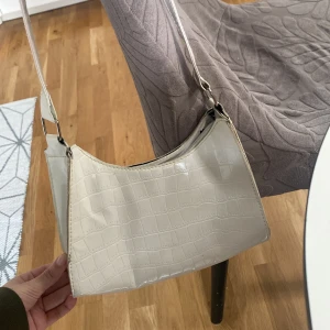 Vit axelväska  - En jättesöt vit väska med coolt mönster. Knappt använd. Man får plats med ganska mycket.❣️Väskan är 24cm i bredden och 15 i höjden. 💋