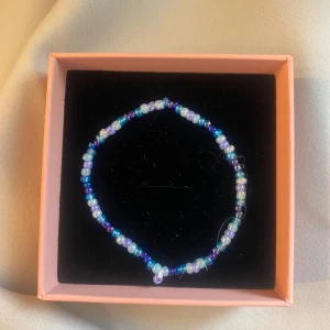 Pärlarmband i blå och lila toner - Ett tunt armband med små pärlor i olika nyanser av blått, lila och vitt. Pärlorna är glansiga och sitter på en elastisk tråd, vilket gör armbandet lätt att ta på och av. Skriv privat om ni vill köpa💜💙🤍