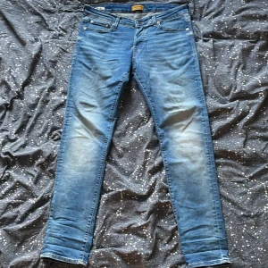 Slim fit jeans från Jack & Jones - Blå slim fit jeans från Jack & Jones, modell Glenn. Jeansen är tillverkade i stretchig denim för extra komfort och har smal passform hela vägen ner.