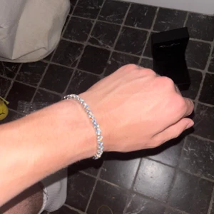 Glittrande tennis armband - Snyggt och glittrigt tennisarmband i silverfärg med runda, gnistrande stenar längs hela bandet. Armbandet har en klassisk och stilren design som verkligen poppar på handleden. Perfekt för sommaren! Klocklådan ej inkluderad.