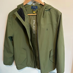Ralph lauren vindjacka  - Snygg olivgrön vindjacka från Ralph Lauren i storlek 14-16 (barn Large). Passar som bäst mellan 160-170. Tveka inte på att ställa frågor eller be om fler bilder 