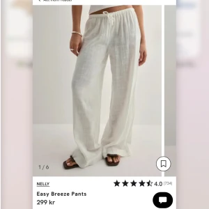 Vita linnebyxor från Nelly - Luftiga och lätta vita linnebyxor från Nelly med breda ben och dragsko i midjan. Perfekta för varma dagar, med relaxed fit och snyggt flowy material. Byxorna har en enkel och stilren look som passar till allt.
