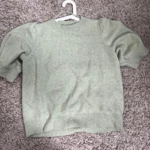 Ljusgrön stickad tröja Vero Moda - Superfin ljusgrön stickad tröja från Vero Moda med puffiga korta ärmar och ribbade muddar. Perfekt för dig som gillar en enkel men ändå trendig look. Mjuk och skön, passar till både jeans och kjol. Bilden får inte riktigt fram dess gröna färg men den är grönare i verkligheten💚
