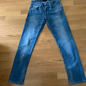 Replay Grover blå jeans straight fit - Säljer ett par Replay Grover jeans i klassisk blå tvätt. Jeansen har raka ben, normal passform och snygga slitningar för en avslappnad look. Tillverkade i mjukt bomullsjeansmaterial med fem fickor och dragkedjegylf.