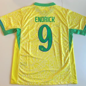 Brasilien Endrick #9 matchtröja Nike - Säljer en officiell Brasilien fotbollströja replika från Nike med Endrick och nummer 9 på ryggen. Tröjan är gul med gröna detaljer, har korta ärmar och ett unikt grafiskt mönster. Broderat CBF-märke och Nike-logga framtill. Perfekt för dig som älskar landslagsfotboll. Endast handtvätt
