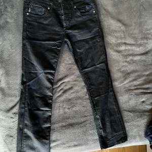 Mörkblå jeans från Jack & Jones - Säljer ett par snygga jeans från Jack & Jones  i storlek 30/30, i nyskick. Jeansen har en mörk tvätt och är tillverkade i mjukt denimtyg som sitter skönt på kroppen. Perfekta för dig som gillar en stilren look.