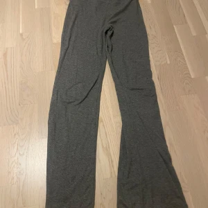 Grå mjukisbyxor från Gina Tricot - Mysiga grå mjukisbyxor från Gina Tricot i storlek 158/164. Byxorna har en rak och lite loose passform med hög midja och är tillverkade i mjukt bomullsmaterial. Perfekta för chill dagar hemma eller när du vill vara bekväm.