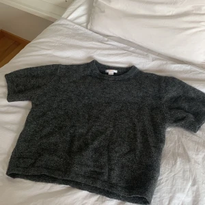 mörkgrå stickad t-shirt/tröja - Gina Tricot - mysig kortarmad stickad tröja i mörkgrå från Gina Tricot! jättefin och enkel att stylea! har använt den rätt så mkt men har i inga större tecken på användning! pris kan diskuteras!