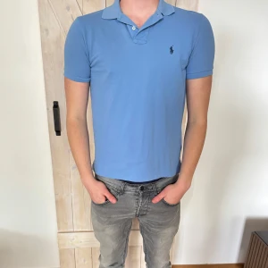Blå pikétröja från Ralph Lauren - Klassisk ljusblå pikétröja från Ralph Lauren. Storleken är S och skicket är väldigt bra.