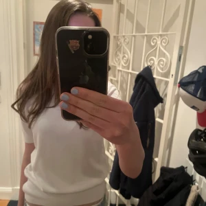 Vit stickad kortärmad tröja från Zara - En stilren vit stickad tröja från Zara med korta ärmar och rund hals. Tröjan har en ribbad nederkant. Säljer pga att jag inte använder den längre men verkligen en superfin tunt stickad kortärmad tröja som passar både till sommar och vinter!!! Tröjan är i bra skick men om man kollar väldigt noga kan man se att den inte är helt ny!