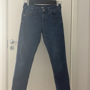 Blå jeans från Tom Tailor, strl 158 - Snygga blå jeans från Tom Tailor i klassisk modell. Jeansen har fem fickor, raka ben och är tillverkade av återvunnet material. Perfekta för dig som gillar en enkel och tidlös stil. Passar dig som har storlek 158 eller M/L. Helt oanvända jeans skick 10/10