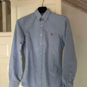 Polo Ralph Lauren Skjorta - Tja säljer nu min Raffe skjorta då den inte passar. Köpt i april, aldrig använd så den är helt ny. Skjortan är i storlek S och slim fit. Nypris 1700 kr, skriv vid minsta fundering👊🏼