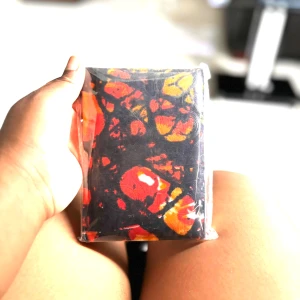 Handgjord anteckningsbok med färgstarkt omslag - En unik anteckningsbok med ett färgstarkt, abstrakt mönster i rött, orange och svart. Perfekt för dig som vill skriva ner tankar, idéer eller skisser. Liten och smidig att ta med överallt – gör din vardag mer kreativ! Följ oss för mer på Instagram; @shop_with_tyra