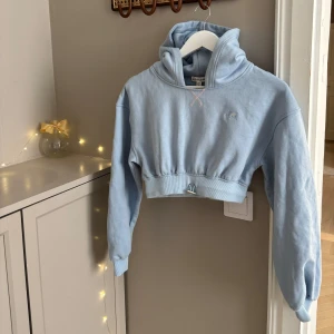 Mjukis-set från For Love & Lemons - Superfin ljusblå croppad hoodie och matchande mjukisbyxor från For Love & Lemons. Säljs som ett set. 