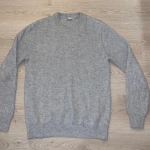 Grå ribbstickad tröja från Zara - Säljer en grå ribbstickad tröja från Zara. Tröjan har rund halsringning och långa ärmar. Materialet är mjukt och skönt.