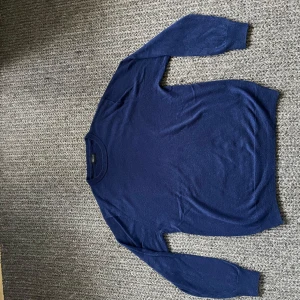 Sweatshirt - En stilren mörkblå stickad tröja från Swedish Fashion. Tröjan har rund halsringning och långa ärmar, perfekt för lager-på-lager. Enkel design som funkar till många olika looks. Materialet känns mjukt och bekvämt mot huden.