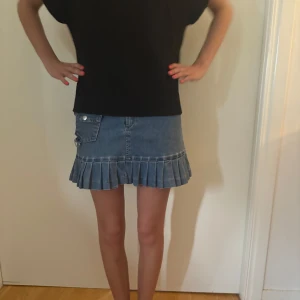 Plisserad jeanskjol från S.Y.L. Jeans - Supersnygg blå jeanskjol med plisserad nederkant och coola detaljer som fickor!