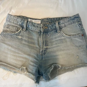 Jeansshorts  - Snygga ljusblå jeansshorts från Zara med fransiga kanter och slitna detaljer. Storlek 34. De är low waist/ mid waist. Pris kan diskuteras vid snabb affär!🥰