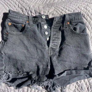 Levi's Ribcage svarta jeansshorts - jag säljer mina svarta jeansshorts från Levi’s då jag har vuxit ur de!! de är så otroligt snygga och shortsen har hög midja 💗de sitter väldigt bra i midjan och där bak! 