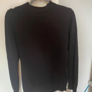 Svart stickad tröja från H&M - En svart stickad tröja från H&M i slim fit-modell. Tröjan har rund halsringning och långa ärmar, perfekt för lager-på-lager. Enkel och stilren design som funkar till det mesta. Materialet är mjukt och bekvämt.