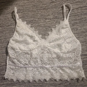 Vitt spetslinne med mönster av blommor - Vitt linne med spets. Osäker på storlek men väldigt stretchig så passar mig som är S och M. Underdelen är genomskinlig och kuporna vita, så ingen bh behövs. Justerbara axelband. Aldrig använd. Skriv för fler bilder😁