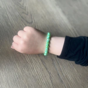 Grönt pärlarmband med silverlås - Snyggt armband med gröna pärlor och små platta detaljer mellan varje pärla. Armbandet har ett silverfärgat klolås som gör det enkelt att ta av och på. Perfekt accessoar för att ge din outfit lite extra färg och personlighet. Just nu har vi två av denna sorten.
