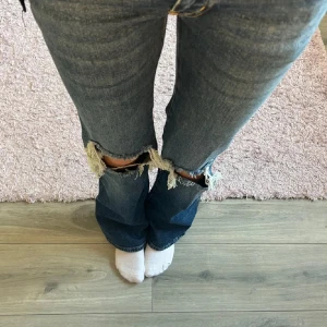 Blåa jeans med hål - Säljer ett par blå jeans från 157 med stora hål vid knäna. De är använda väldigt fåtal gånger så de är i väldigt bra skick!