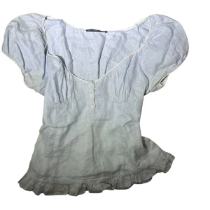 Ljusblå blus med volang och puffärm - Supersöt ljusblå blus med puffiga korta ärma. 