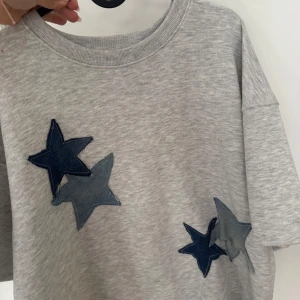 Grå tjocktröja med stjärnor - Grå fin tjocktröja med jeans stjärnor, köpt av Uf företag ❤️❤️ den är kortärmad 
