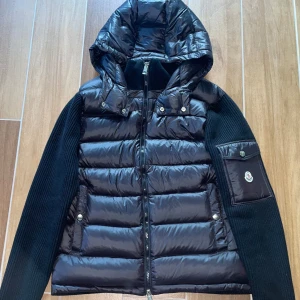 Ny Moncler Cardigan med luva - Moncler Cardigan i nyskick - aldrig använd. Storlek M men kan passa S. Väldigt clean och sällsynt modell. Den är gjord av skönt material och sitter sjukt bra på kroppen. Passar alla outfits och matchar med alla färger. Kan frakta samt mötas upp!