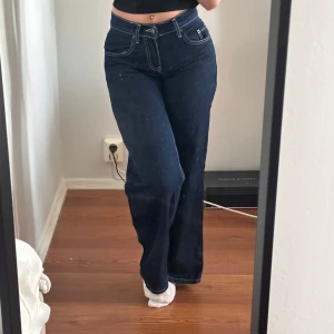Mörkblå low waist jeans Subdued - Säljer ett par mörkblå jeans från Subdued i low waist-modell. Byxorna har raka ben, kontrastsömmar och klassiska fickor fram och bak. Materialet är jeans med en skön känsla och passformen är loose och avslappnad.