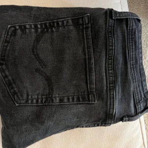 Svarta jeans i rak modell, stl 31/32 - Obs!!! Om ni köper Jeansen så köp via PostNord annars så avbryter jag köpet. Säljer ett par svarta jeans i klassisk rak modell. Jeansen har fem fickor, snygga sömmar på bakfickorna och normal passform. Perfekta till sneakers och funkar året runt. Storlek 31/32.