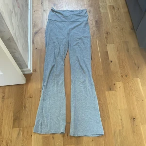 Grå jogapants  från Gina Tricot - Snygga grå bootcut byxor från Gina Tricot i mjukt bomullsmaterial. De har hög midja och en skön, stretchig passform som sitter bekvämt. Perfekta för en chill och avslappnad stil, med breda ben som ger en trendig siluett.