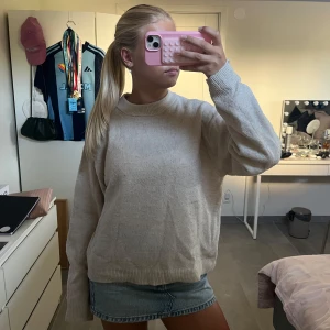 Beige stickad tröja från H&M XS - Mysig beige stickad tröja från H&M i storlek XS. Tröjan har rund hals, ribbade muddar och en loose passform. Perfekt att slänga på sig när det är lite kyligt ute. Enkel och stilren design som funkar till jeans eller kjol.