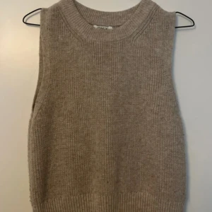 Beige stickad väst från Only - Säljer en beige stickad väst från Only med bred ribbad kant vid hals och nederdel. Går att ha på många olika sätt