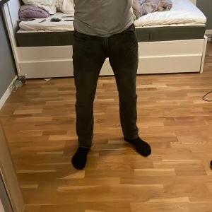 Svarta jeans från Jack & Jones - Säljer ett par svarta jeans från Jack & Jones med snygg tvättad look. Jeansen har klassisk femficksdesign, normal passform och raka ben. Tillverkade i mjukt jeanstyg som sitter skönt hela dagen.