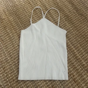Vit ribbad linnetopp med smala band - Säljer en  vit topp med smala axelband och ribbat material. 