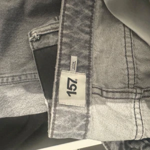 Grå jeansbyxor från 157, storlek S - Snygga grå jeansbyxor från 157 i storlek S. Klassisk femficksmodell med ljusgrå tvätt och raka ben. Perfekta för dig som gillar en enkel och clean look. Materialet är jeans och byxorna har en normal passform.