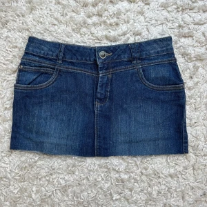 Mörkblå jeanskjol med fickor - Snygg mörkblå lågmidjad jeanskjol 💓 midjemåttet är 39cm rakt över o kjolen är 29cm lång. Skriv vid frågor!