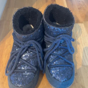 Blå glittriga Moon Boots från Inuikii -  säljer mina inuikii för dem kommer inte till användning dem är lite slitna vid Skosnörena hör av er om ni har några frågor eller vill ha mer bilder. 