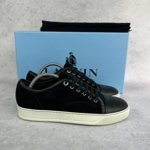 Lanvin DBB1 cap toe sneaker - – Condition: 9/10  - Size: 40/UK6  – What is included: Dustbag  – Retail price: 6000 + SEK  Please note that Lanvins fit big and our recommendation is to go one size down