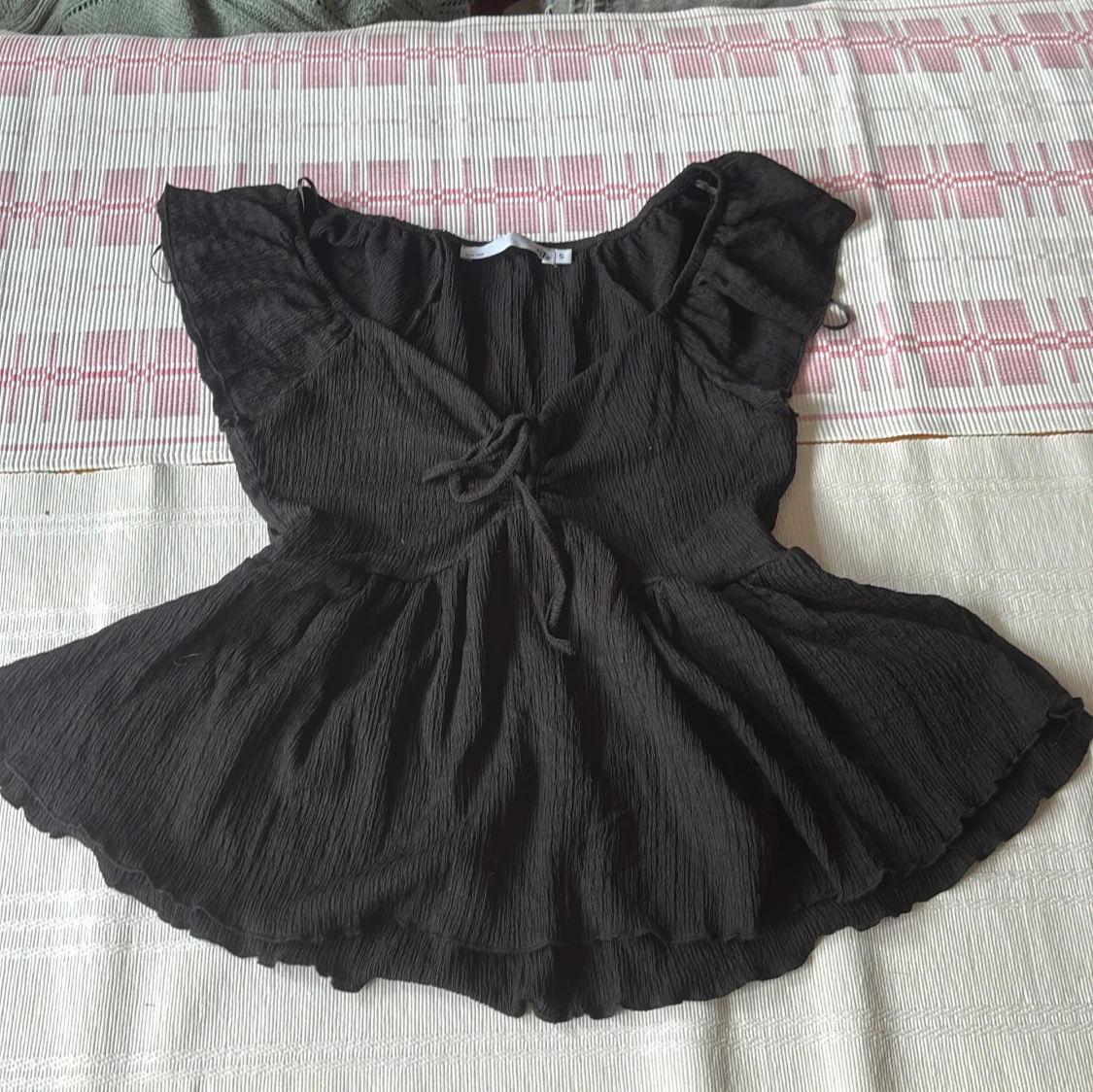 Svart blus med volang och knyt